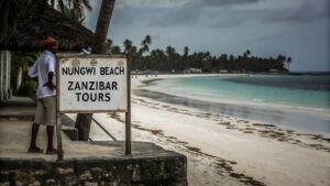 Visitors interacting with street hawkers on Nungwi Beach in Zanzibar